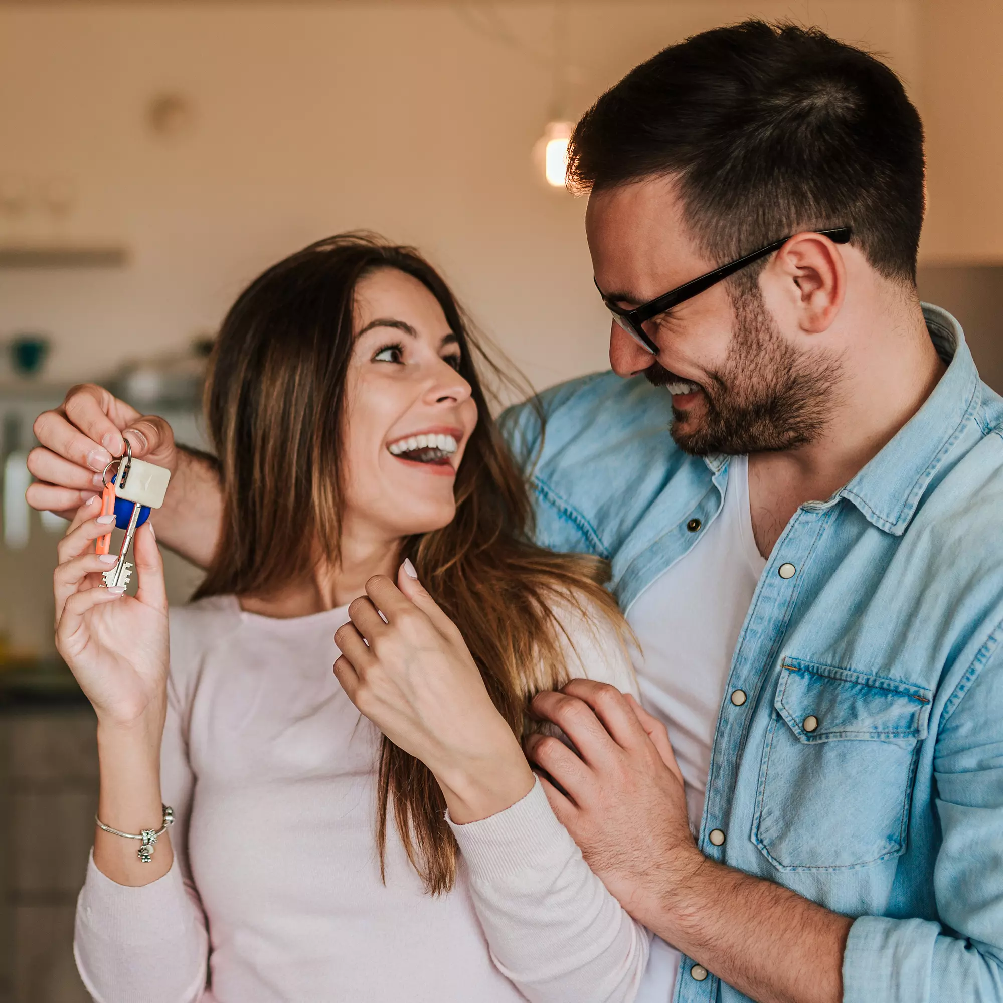 Pareja feliz con las llaves de su nueva casa