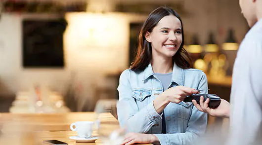 Pago sin contacto Mujer realizando el pago de sus compras con tarjetas LAFISE