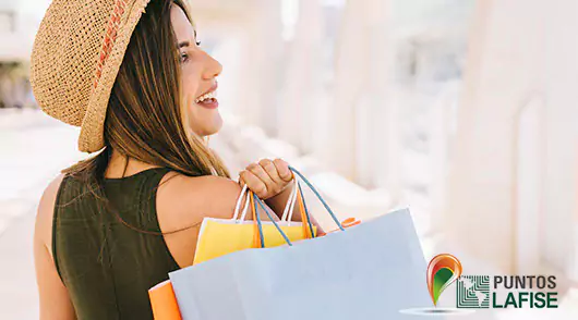 Puntos LAFISE Mujer cargando las bolsas de sus compras