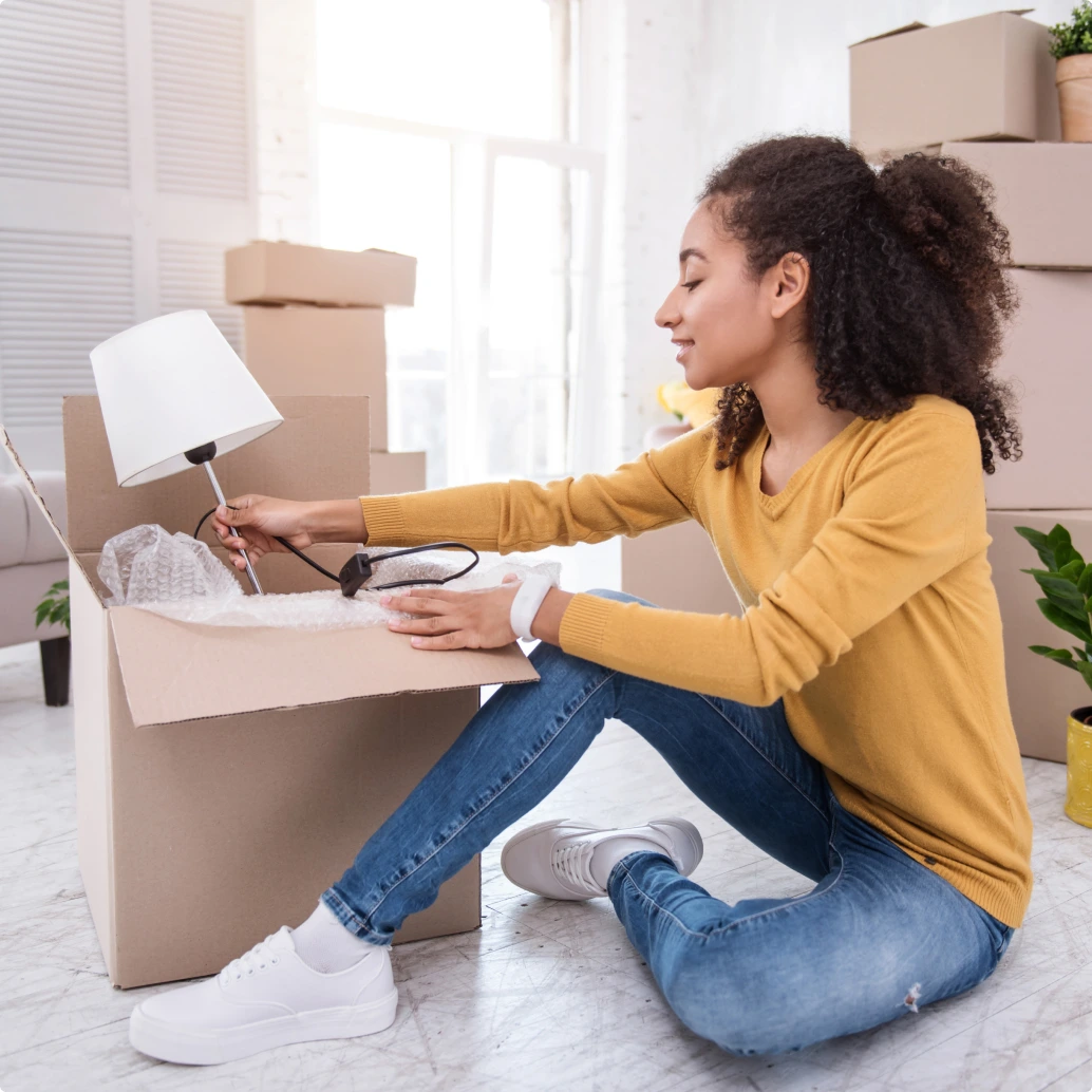 Mujer joven abriendo caja con sus compras