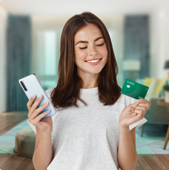 Joven chica sonriente mira su celular y su nueva tarjeta
