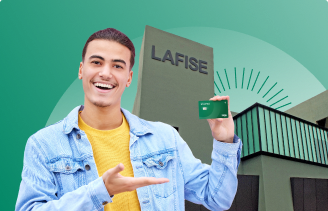 Hombre alegre frente a sucursal LAFISE con su tarjeta de débito LAFISE