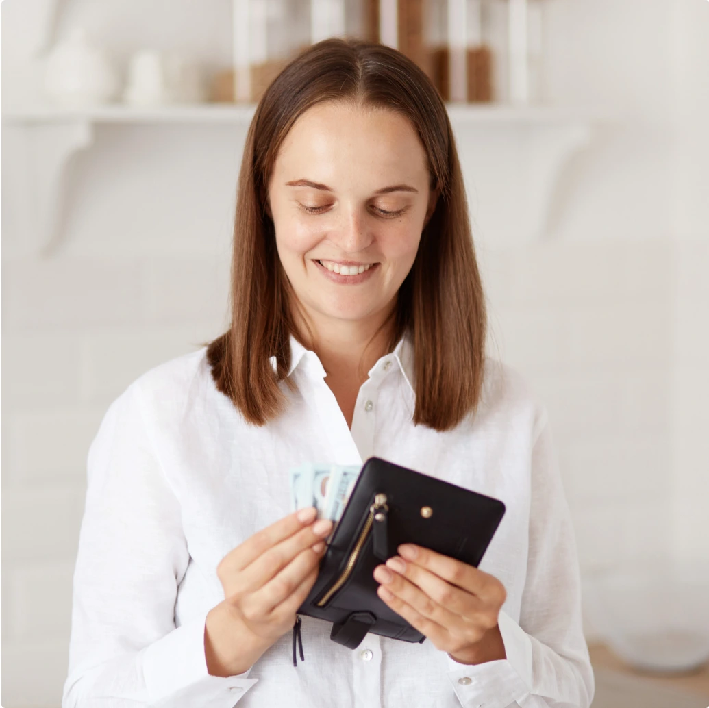 Mujer metiendo dinero en su billetara