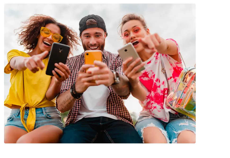 Grupo de jóvenes en un jardín viendo contenido en su celular