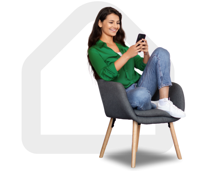 Mujer sonriente viendo su celular sentada en sillon solicitando su prestamo de vivienda con LAFISE