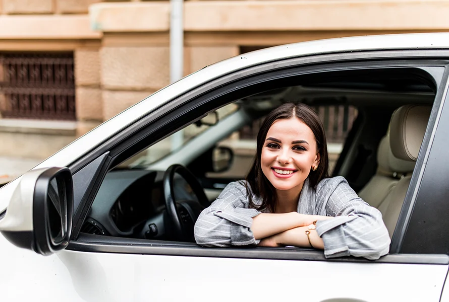 Mujer sonriendo sobre ventana de auto