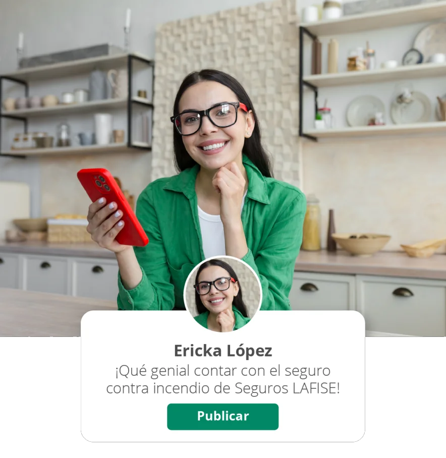 Chica en la cocina sonriendo a la cámara mientras sostiene su celular.