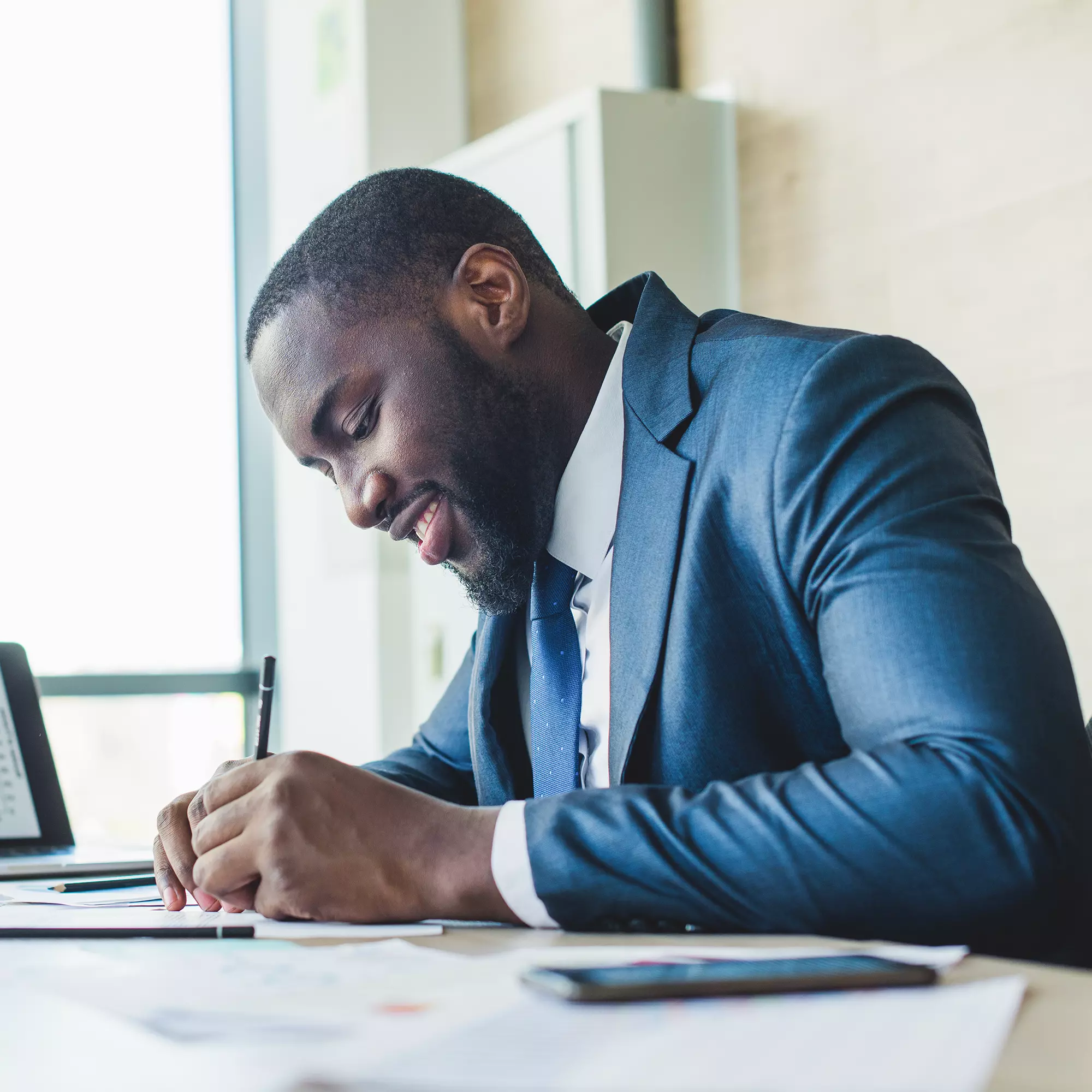 Joven en una empresa firmando cheques Joven en una empresa firmando cheques