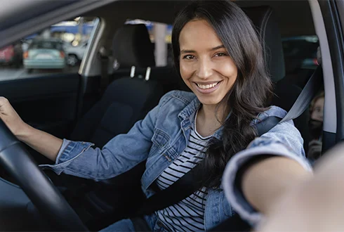 Mujer sonriente al volante de auto