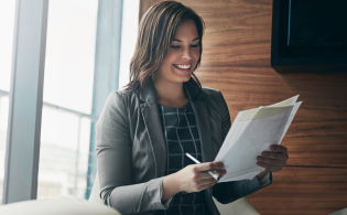 Mujer empresaria feliz revisando los contratos empresariales